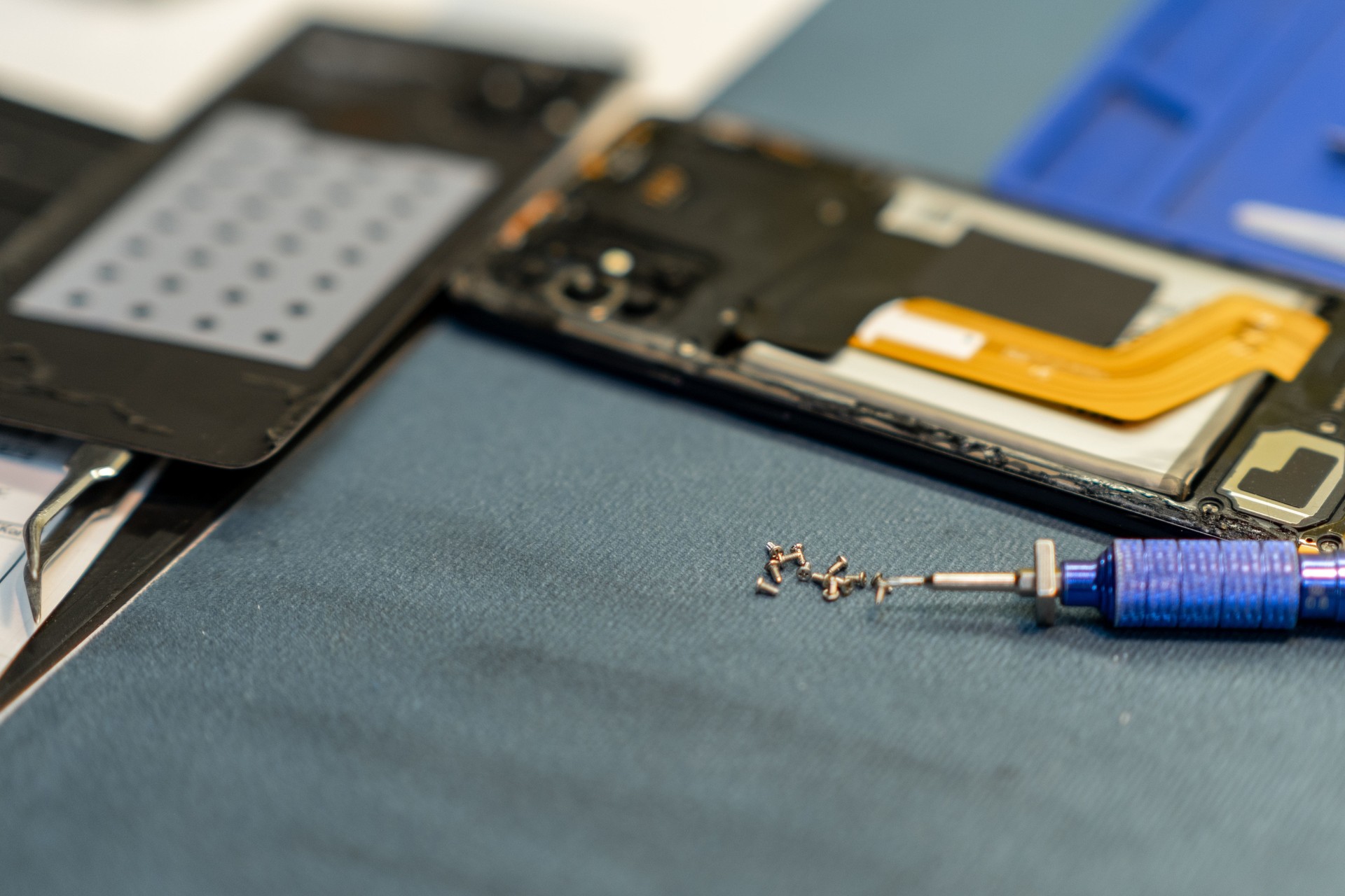 Professional Phone Repair With Tools and Components Laid out on a Workbench in a Workshop
