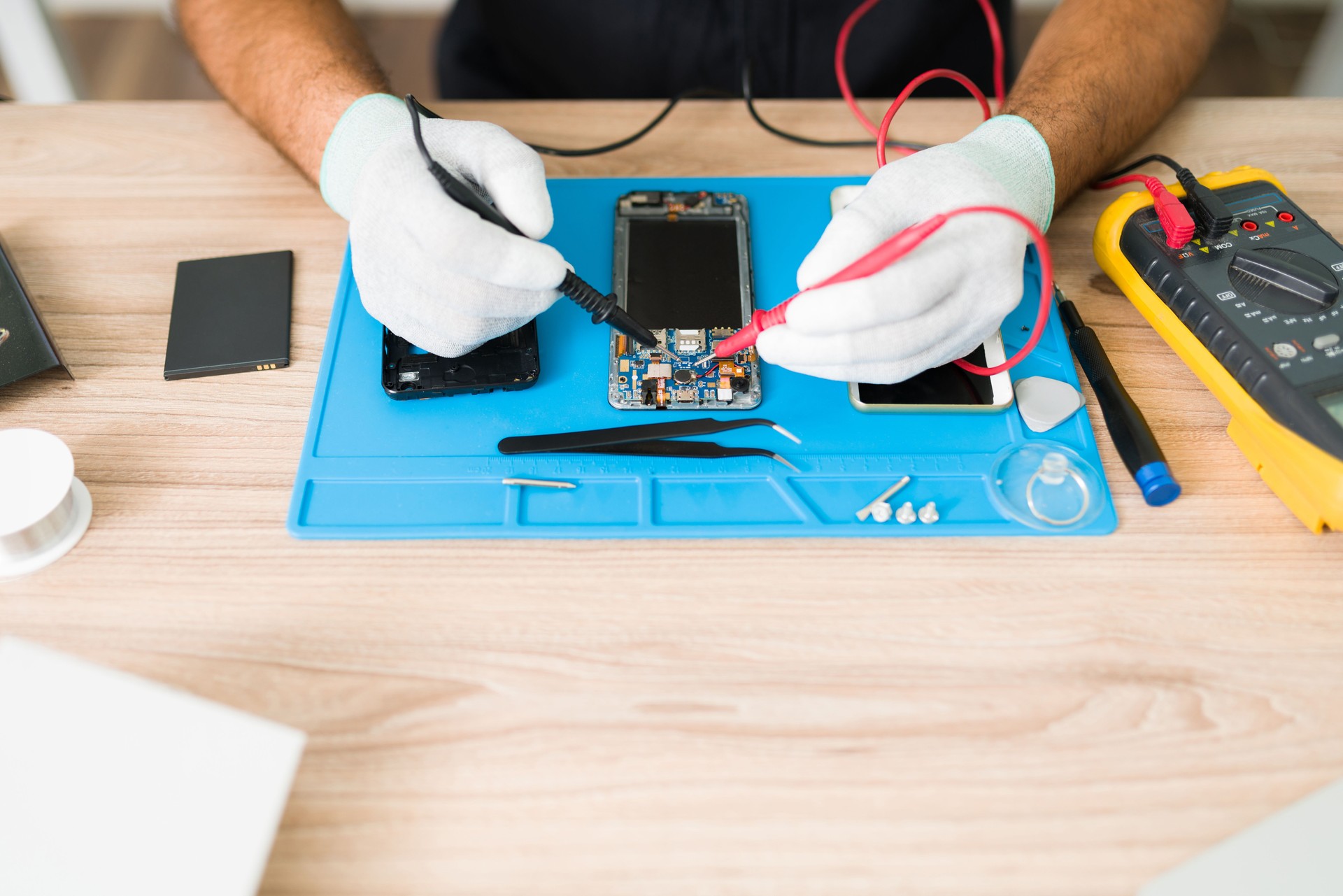 Top view of a technician checking the connections on a smartphone